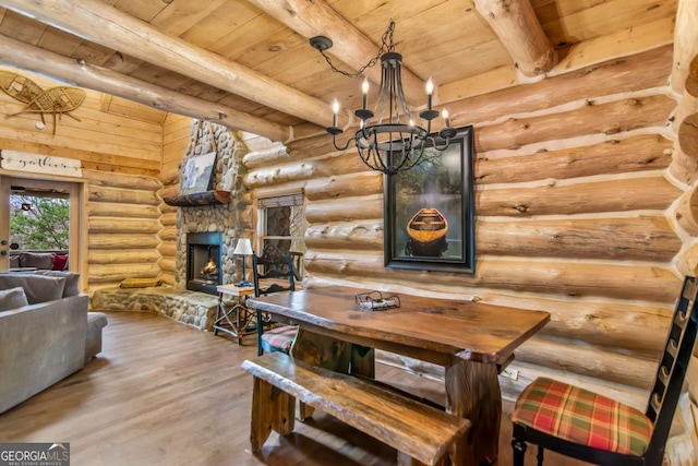 dining room featuring beam ceiling, a fireplace, wood ceiling, and wood finished floors