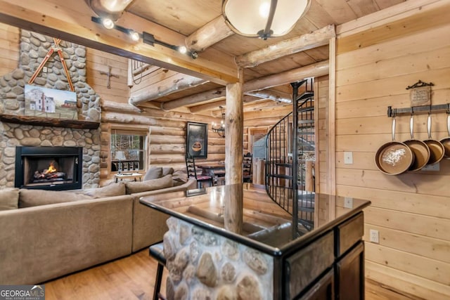 living room featuring beamed ceiling, stairway, light wood-style floors, a fireplace, and wood ceiling