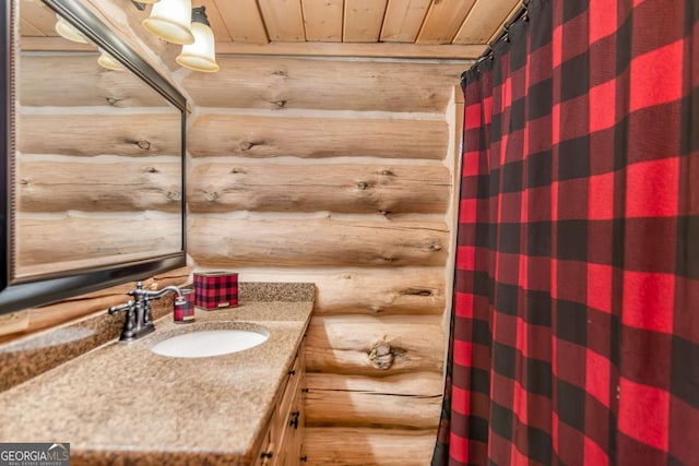 bathroom featuring rustic walls, a shower with curtain, wooden ceiling, and vanity