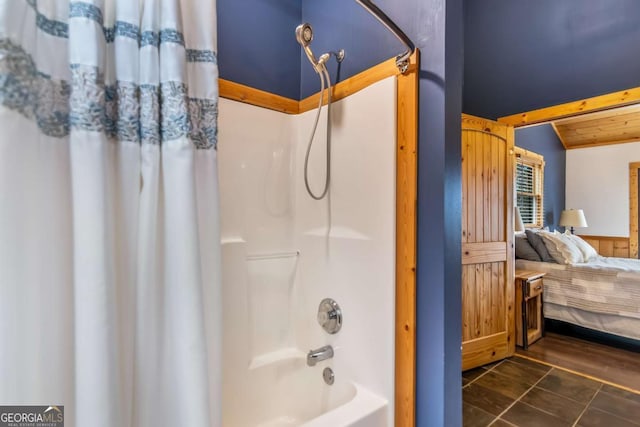 bathroom with a wainscoted wall, shower / bath combo with shower curtain, lofted ceiling with beams, connected bathroom, and tile patterned flooring