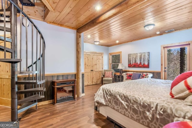 bedroom with visible vents, a wainscoted wall, wooden ceiling, wood finished floors, and access to outside