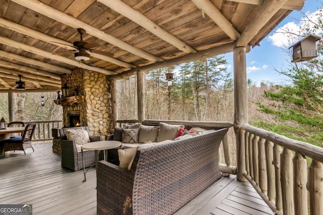 wooden terrace featuring an outdoor living space with a fireplace and a ceiling fan