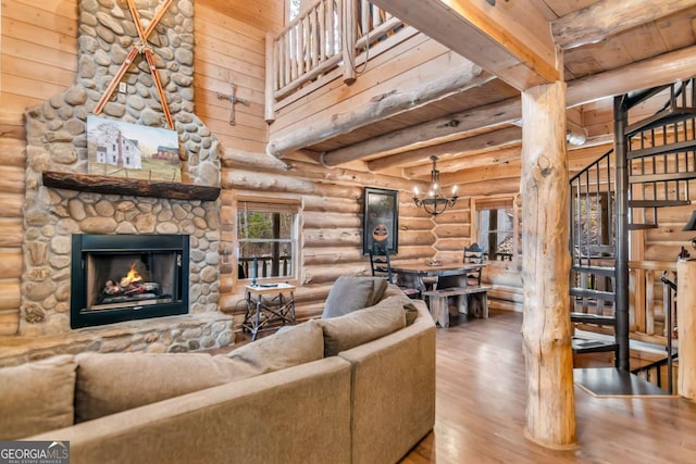 living room featuring stairway, beam ceiling, wood finished floors, and a fireplace