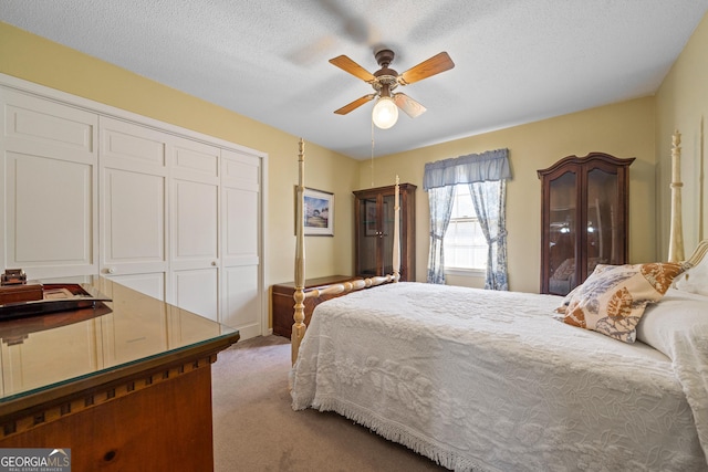 bedroom with a closet, carpet flooring, a textured ceiling, and ceiling fan