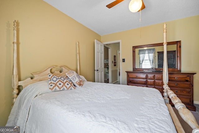 carpeted bedroom with a ceiling fan and vaulted ceiling