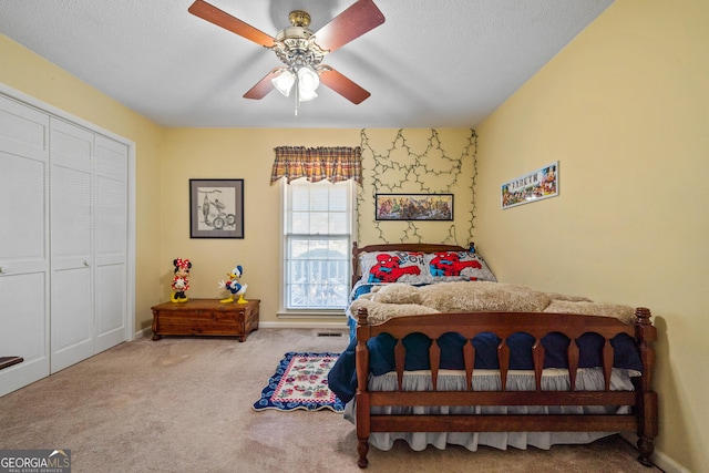 carpeted bedroom featuring a textured ceiling, a ceiling fan, a closet, and baseboards