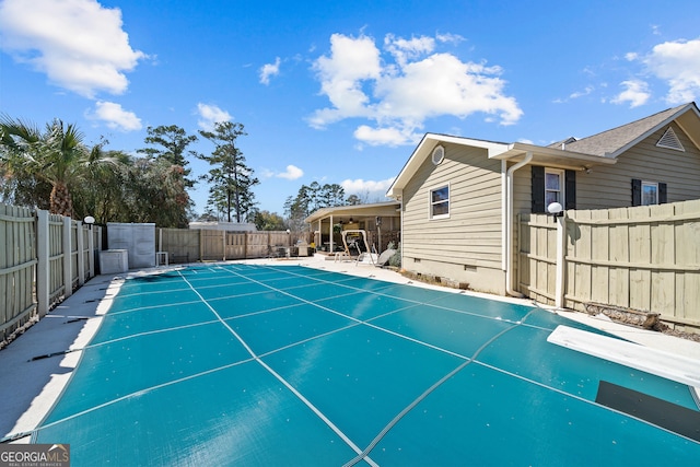 view of pool with a diving board, a fenced in pool, and a fenced backyard