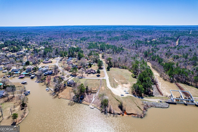 aerial view featuring a wooded view and a water view