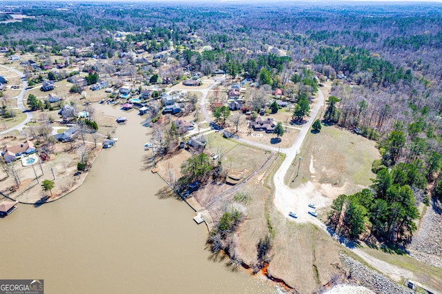 drone / aerial view featuring a view of trees and a water view