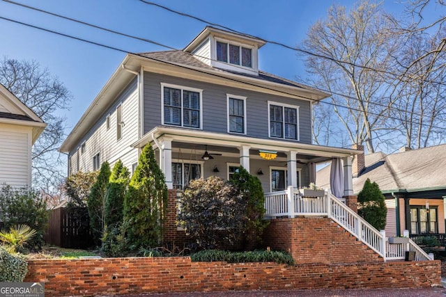 american foursquare style home with covered porch and a ceiling fan