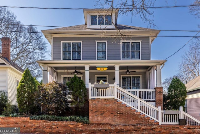 american foursquare style home featuring stairway, covered porch, and a ceiling fan