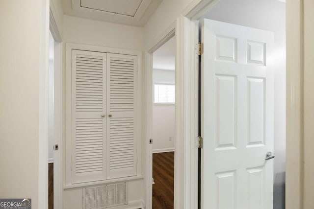 hallway with visible vents, baseboards, and dark wood-type flooring