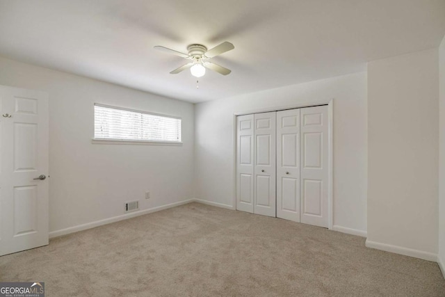 unfurnished bedroom featuring visible vents, baseboards, carpet, a closet, and a ceiling fan