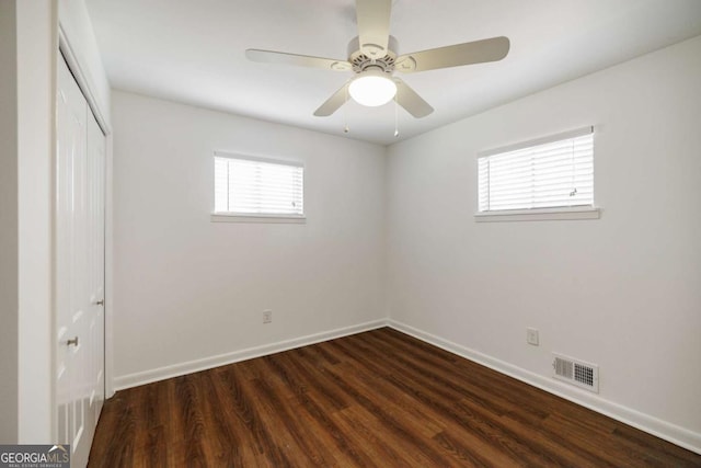 unfurnished bedroom with visible vents, dark wood finished floors, a closet, baseboards, and ceiling fan