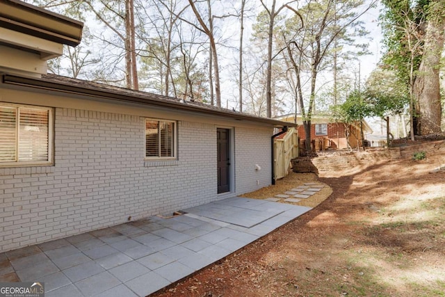 doorway to property featuring brick siding and a patio area