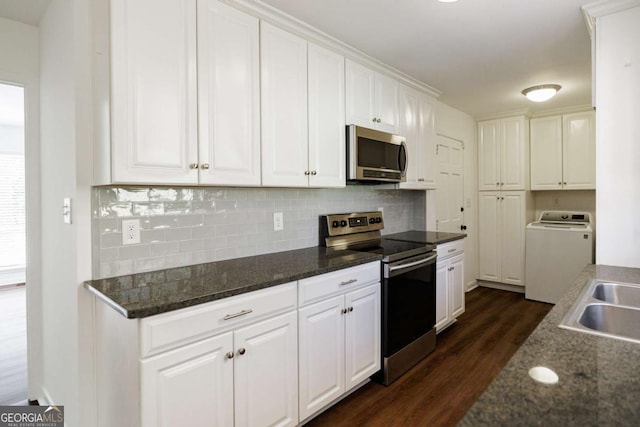 kitchen with dark wood finished floors, stainless steel appliances, white cabinets, washer / clothes dryer, and a sink