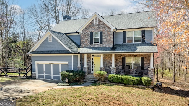 craftsman inspired home featuring a front yard, an attached garage, covered porch, concrete driveway, and stone siding