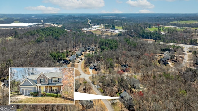 birds eye view of property featuring a wooded view