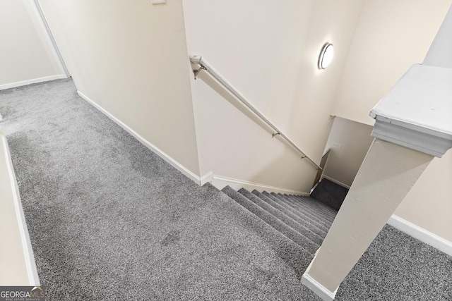 stairway featuring baseboards and carpet floors