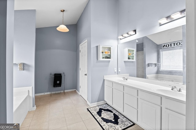 bathroom featuring tile patterned floors, a bath, and a sink