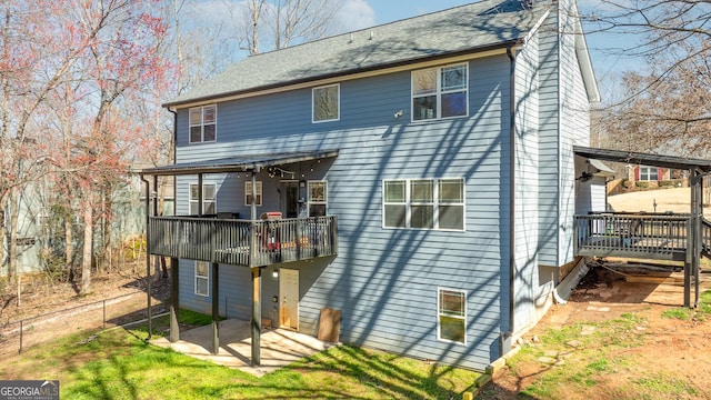 back of house featuring fence, a yard, a wooden deck, a chimney, and a patio area