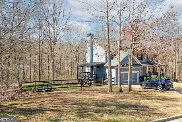 view of front of property with a garage, a chimney, and a front lawn