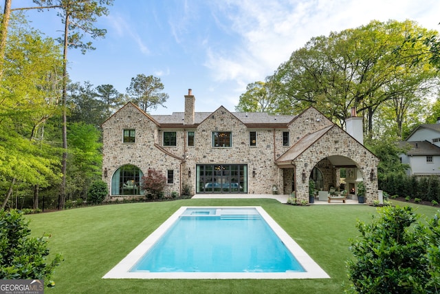 41 Blackland Rd NW, Atlanta, GA 30342 - rear view of property featuring a chimney, an outdoor pool, a patio, a lawn, and brick siding