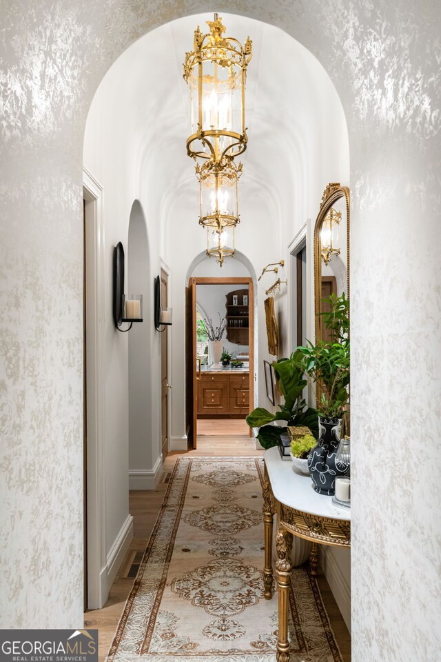 41 Blackland Rd NW, Atlanta, GA 30342 - corridor featuring light wood-style floors, visible vents, arched walkways, and a notable chandelier