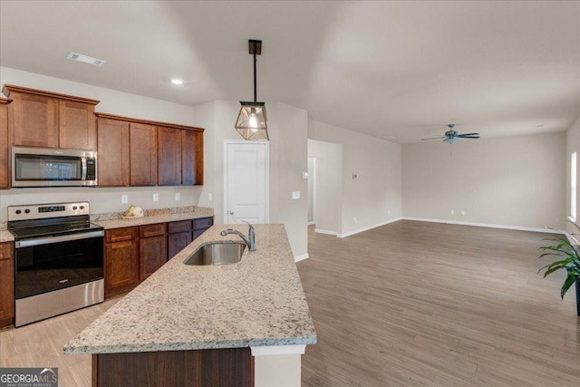 kitchen with light wood finished floors, visible vents, ceiling fan, stainless steel appliances, and a sink