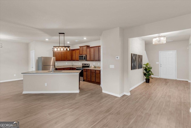 kitchen featuring a sink, stainless steel appliances, baseboards, and light wood-style flooring