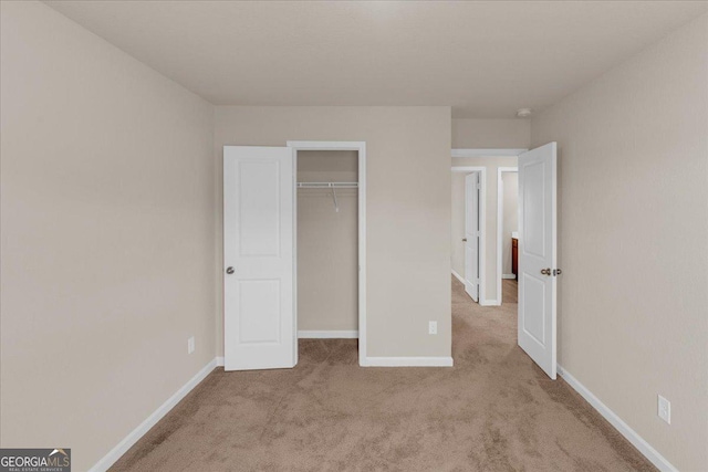 unfurnished bedroom with carpet, baseboards, and a closet