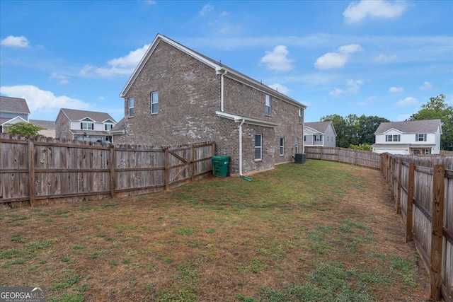 view of yard with a fenced backyard and central AC