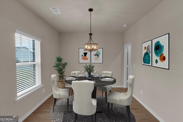 dining space featuring visible vents, baseboards, and wood finished floors