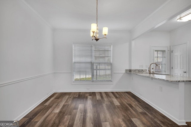 unfurnished dining area with an inviting chandelier, ornamental molding, dark wood-type flooring, and a sink