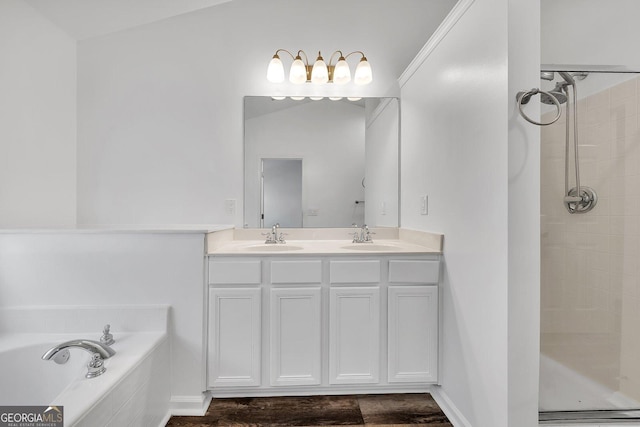 bathroom featuring a sink, a garden tub, double vanity, and a tile shower