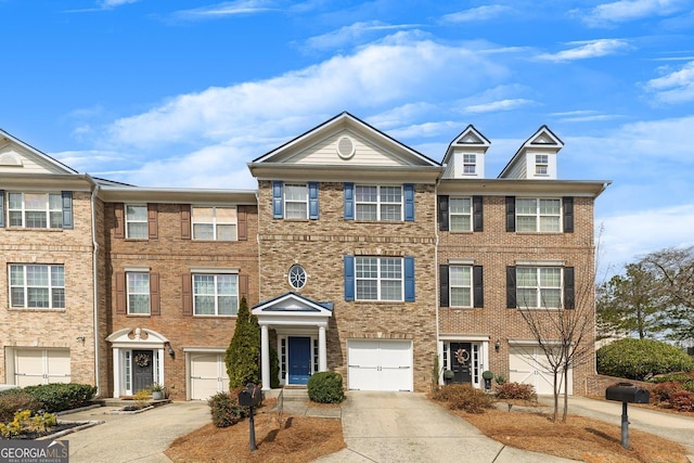 townhome / multi-family property featuring an attached garage, brick siding, and driveway