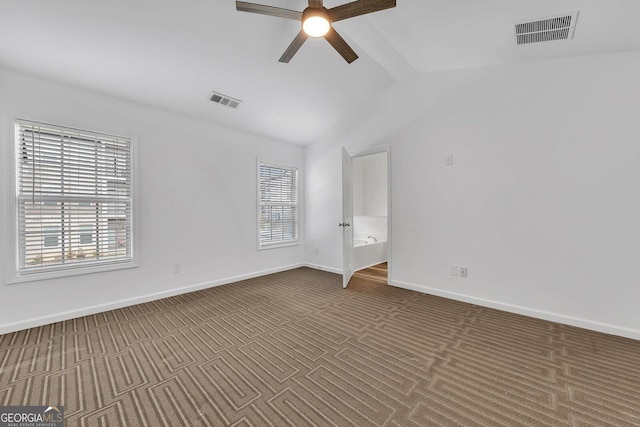 empty room with visible vents, baseboards, a ceiling fan, and vaulted ceiling