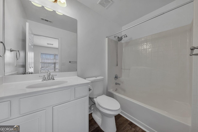 full bath featuring  shower combination, toilet, wood finished floors, and visible vents