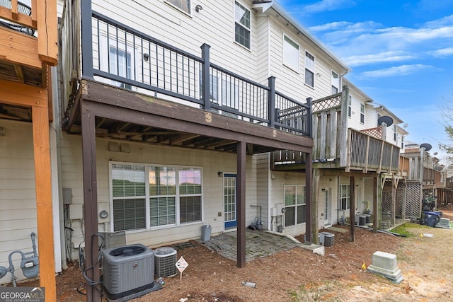 rear view of house featuring cooling unit, a deck, and a patio area