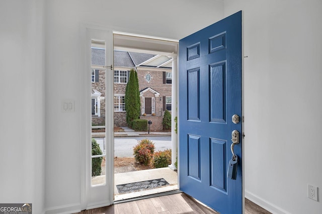 foyer entrance with baseboards and wood finished floors