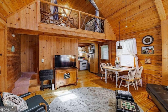 living area with high vaulted ceiling, wood walls, wood ceiling, and light wood-type flooring