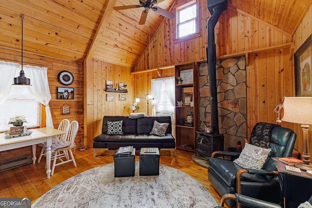 living room with wood-type flooring, wooden walls, wooden ceiling, and a wood stove