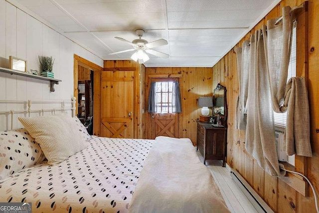 bedroom featuring a baseboard heating unit and ceiling fan