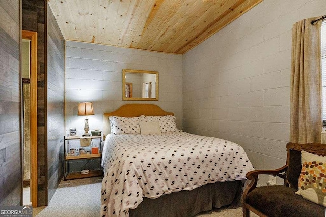 bedroom featuring wood ceiling and concrete block wall