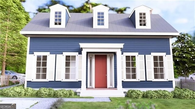 view of front of home featuring metal roof and fence