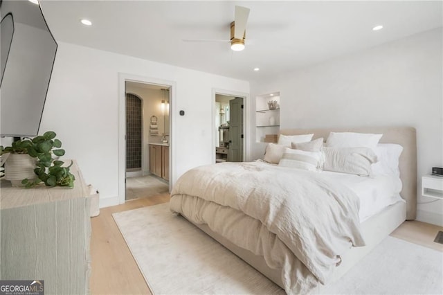 bedroom featuring recessed lighting, light wood-style flooring, and ensuite bath