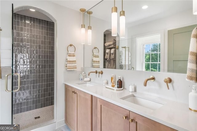 full bathroom with double vanity, a stall shower, and a sink