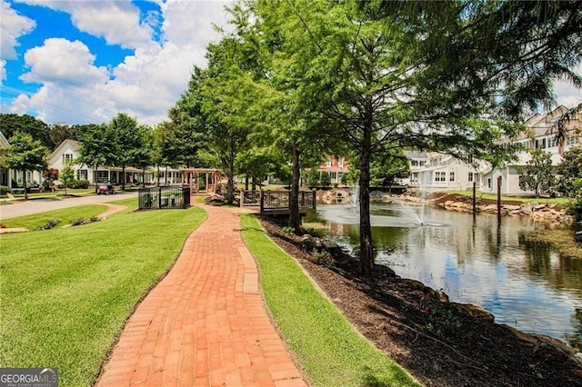 view of community with a yard and a water view
