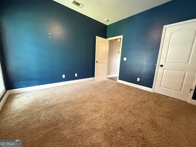 unfurnished bedroom featuring carpet, visible vents, and baseboards