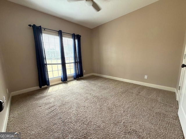 carpeted spare room with baseboards and ceiling fan